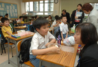 卫生署助理署长程卓端医生探访一间小学和学生交谈，了解学童的饮食习惯。